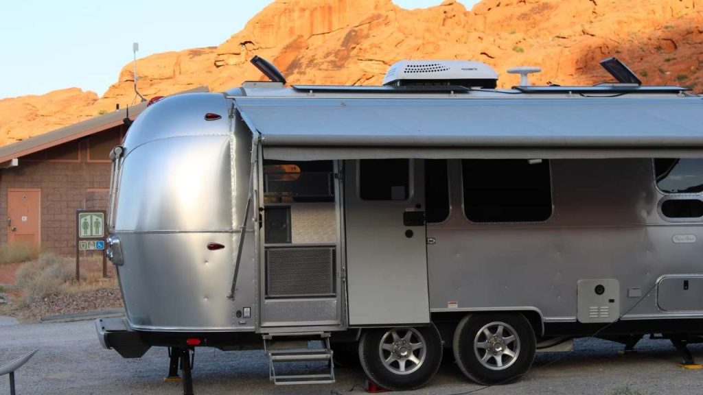 A silver trailer parked in front of a mountain